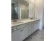 Bathroom with dual sinks, white cabinets, quartz countertop, large mirror and marble floors at 124 Ireland Dr, Summerville, SC 29486