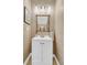 Neutral powder room featuring a decorative mirror, patterned wallpaper, and a white vanity at 1682 Camfield Ln, Mount Pleasant, SC 29466