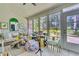 Bright sunroom with large windows, cozy seating, and a view of the surrounding greenery at 1682 Camfield Ln, Mount Pleasant, SC 29466