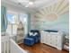 Bright Bedroom with white cribs, blue accent chair, and mural wall art at 1722 Trewin Ct, Charleston, SC 29492