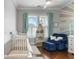 Bright Bedroom with white cribs, blue accent chair and nautical-themed decor at 1722 Trewin Ct, Charleston, SC 29492