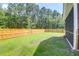 Fenced backyard backing up to wooded area with a manicured lawn at 1888 Nola Run, Summerville, SC 29485