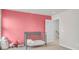 Cozy bedroom with pink accent wall, neutral carpet, and gray crib at 1888 Nola Run, Summerville, SC 29485