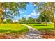 Scenic walking path through the lush green community park with beautiful landscaping and nearby houses in the background at 1888 Nola Run, Summerville, SC 29485