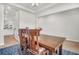 Bright dining room featuring a wooden table, patterned rug, and large windows offering view to the kitchen at 1888 Nola Run, Summerville, SC 29485