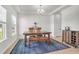 Bright dining room featuring a wooden table, patterned rug, and large windows at 1888 Nola Run, Summerville, SC 29485