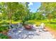 Outdoor fire pit area with Adirondack chairs and shade trees at 1888 Nola Run, Summerville, SC 29485