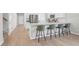 Modern kitchen with white cabinets, stainless steel appliances, and a spacious island with barstool seating at 1888 Nola Run, Summerville, SC 29485