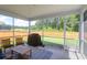 Relaxing screened porch with outdoor seating and a grill overlooks the spacious, fenced backyard at 1888 Nola Run, Summerville, SC 29485