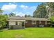 Charming brick home boasts a spacious backyard with lush green grass and mature trees at 1900 Morgan Ave, North Charleston, SC 29406