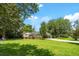 Inviting home with a sprawling green lawn, shade trees, and a carport, combining comfort and outdoor enjoyment at 1900 Morgan Ave, North Charleston, SC 29406
