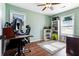 This bedroom features light green walls, wood floors, a ceiling fan, and a desk area with a computer setup at 214 E Edgefield Dr, Summerville, SC 29483