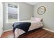 A cozy bedroom with hardwood floors, a circular mirror, and a single bed with a soft comforter at 214 E Edgefield Dr, Summerville, SC 29483