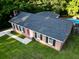 Brick home with a red front door, dark shutters, well-maintained lawn, and a pool in the backyard at 214 E Edgefield Dr, Summerville, SC 29483