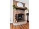 Charming brick fireplace with wooden mantle, decorative plants, and elegant giraffe statuettes at 214 E Edgefield Dr, Summerville, SC 29483