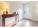 Inviting foyer with hardwood floors, a decorative table with a lamp, and a white front door at 214 E Edgefield Dr, Summerville, SC 29483