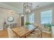 Bright dining room with a rustic wood table, modern lighting fixture, and large windows at 2150 Terrabrook Ln, Charleston, SC 29412