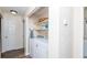 Laundry room with a modern washer and dryer, storage shelf and entry door at 2186 Spoleto Ln, North Charleston, SC 29406