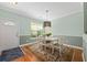 Comfortable dining area with a square white table, colorful rug and hardwood floors at 2961 Sweetleaf Ln, Johns Island, SC 29455
