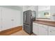Kitchen features a large stainless-steel refrigerator, wood flooring and white cabinets at 2961 Sweetleaf Ln, Johns Island, SC 29455