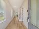 Hallway with a view of the entry door, sidelight window, and staircase in the distance at 299 Lucca Dr, Summerville, SC 29486