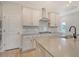 Well-equipped kitchen with grey countertop, stainless hood, white cabinets, and undermount sink at 299 Lucca Dr, Summerville, SC 29486