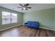 Bright bedroom with hardwood floors, large windows, and a comfortable blue sofa at 3018 Vincent Astor Dr, Johns Island, SC 29455