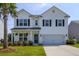 Charming two-story home with a well manicured yard, a palm tree and two car garage at 3018 Vincent Astor Dr, Johns Island, SC 29455