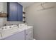 Laundry room boasts sleek cabinets, open shelves, and modern washer and dryer at 3018 Vincent Astor Dr, Johns Island, SC 29455