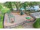 Aerial view of the playground and pool area with mature landscaping and a black perimeter fence at 3018 Vincent Astor Dr, Johns Island, SC 29455
