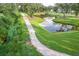 Scenic community walking trail lined with lush landscaping and mature trees next to a peaceful pond at 3018 Vincent Astor Dr, Johns Island, SC 29455