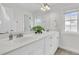 Clean, bright bathroom with double sinks, white cabinets, tile flooring, a large mirror, and great natural light at 3513 Flowering Oak Way, Mount Pleasant, SC 29466