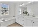 Bathroom with a double vanity, large mirror, garden tub, and a window offering natural light at 3513 Flowering Oak Way, Mount Pleasant, SC 29466