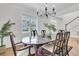 Traditional dining room with hardwood floors, a wooden table set for six, and a view to the yard through a large window at 3513 Flowering Oak Way, Mount Pleasant, SC 29466