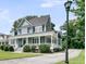 Beautiful blue two-story home with a spacious front porch and manicured lawn showcasing its curb appeal at 3513 Flowering Oak Way, Mount Pleasant, SC 29466