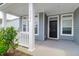 Covered front porch with seating and a beautifully adorned front door at 3524 Great Egret Dr, Johns Island, SC 29455