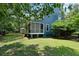 View of backyard with a screened porch, well-maintained lawn, and mature trees at 3574 Toomer Kiln Cir, Mount Pleasant, SC 29466