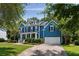 Charming blue two-story home featuring a well-manicured lawn, a columned porch and an attached two-car garage at 3574 Toomer Kiln Cir, Mount Pleasant, SC 29466