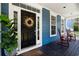 Inviting front porch with rocking chairs and a welcoming front door adorned with a decorative wreath at 3574 Toomer Kiln Cir, Mount Pleasant, SC 29466