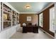 Home office with built-in bookshelves, a large desk, and a window overlooking the landscaped yard at 3574 Toomer Kiln Cir, Mount Pleasant, SC 29466