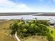 Aerial view of wooded property with waterway access and boardwalk through the marsh at 377 Lofton Ct, McClellanville, SC 29458