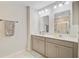 Bright bathroom featuring dual sinks, gray cabinets, and a large framed mirror at 3798 Sawmill Ct, Mount Pleasant, SC 29429