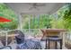 Inviting screened porch featuring a table, chairs and wooded view at 3798 Sawmill Ct, Mount Pleasant, SC 29429