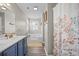 Bright bathroom featuring blue vanity, double sinks, and soaking tub with tile surround at 3810 Marshfield Rd, Johns Island, SC 29455