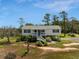 Charming elevated home with a classic white exterior and inviting front staircase, surrounded by a lush landscape at 3810 Marshfield Rd, Johns Island, SC 29455