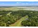 Expansive aerial view showcases the lush golf course, mature trees, and waterfront views at 40 Greensward Rd, Kiawah Island, SC 29455
