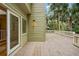 Exterior view of the home's deck, featuring green siding and a glimpse of the lush, private backyard at 40 Greensward Rd, Kiawah Island, SC 29455
