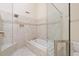 Bathroom showcasing a shower with glass surround, tile, and a soaking tub at 40 Greensward Rd, Kiawah Island, SC 29455