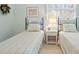 Bright bedroom featuring two twin beds with patterned bedding and a bedside table at 40 Greensward Rd, Kiawah Island, SC 29455