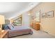 Bright bedroom features a sloped ceiling, fan, and large window overlooking the verdant yard at 40 Greensward Rd, Kiawah Island, SC 29455